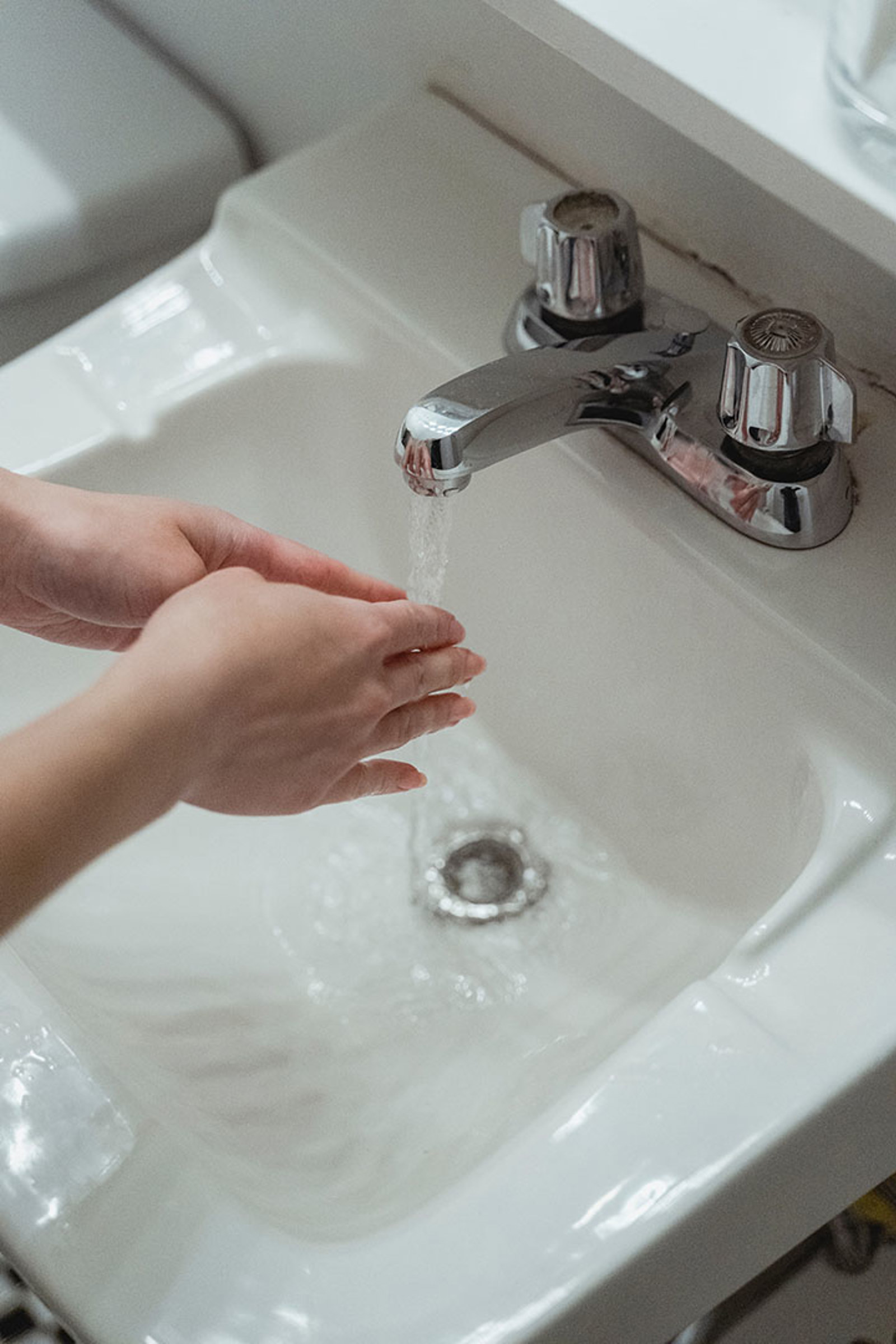 Person washing hands in sink