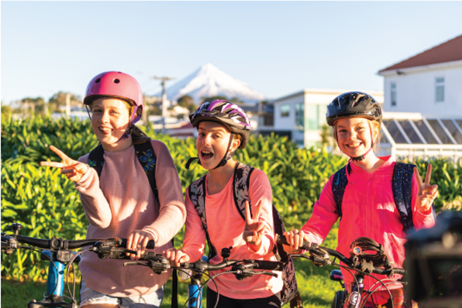 Three girls biking to school. 
