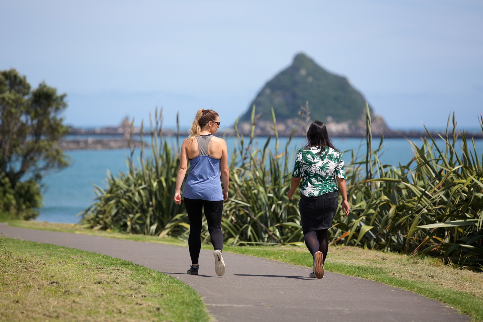 Two women walking on the walkway.
